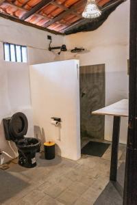 a bathroom with a black toilet and a table at Alto Saudade - Atins in Barreirinhas