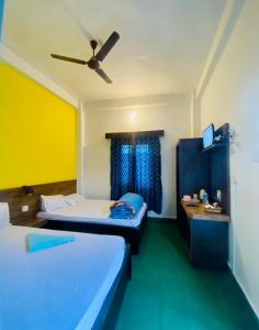 a room with two beds and a ceiling fan at Hotel MAQ Lumbini in Rummindei +85 photos