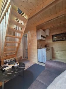 ein Zimmer mit Tisch und Küche in einer Hütte in der Unterkunft Tiny House 3-Imanje Terzić in Golubovci
