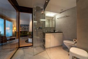 a bathroom with a glass shower and a toilet at Sleek Mountain Escape Light and Airy in Flims +24 photos