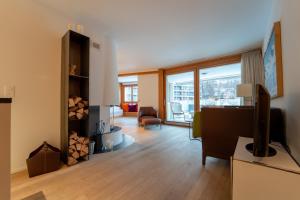 a living room with a desk and a tv in a room at Sleek Mountain Escape Light and Airy in Flims