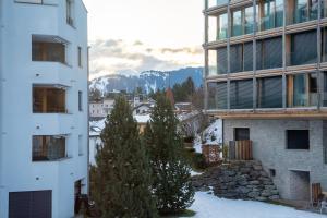 an apartment building with a view of the mountains at Sleek Mountain Escape Light and Airy in Flims