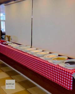 a red and white table with bowls and plates on it at Rawaz Hotel in As Sulaymānīyah +5 photos