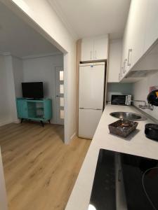 a kitchen with a white refrigerator and a counter top at Alojamiento La Paz in Linares
