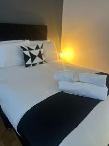 a bedroom with a bed with towels on it at Spacious 4-Bedrooms Corporate Flat - Prime Location in Watford