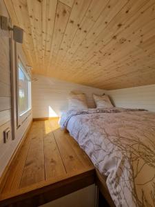a bed in a small room with a wooden ceiling at Little Luxe 2 in Amriswil +28 photos
