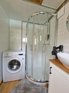 a bathroom with a shower and a washing machine at Little Luxe 2 in Amriswil