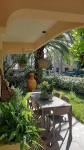 an outdoor patio with a table and chairs with plants at Baki B&B in Rimini