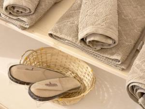 a basket on a shelf with towels and shoes at Tiny House nel cuore del Monferrato in Conzano +16 photos