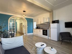 a living room with a couch and a kitchen at L'Arche in Saint-Dizier