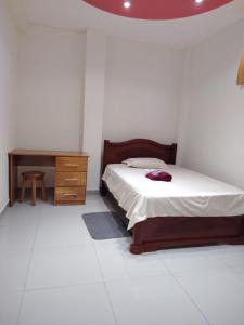 a bedroom with a bed and a wooden dresser at CASA Sebastián in Puerto Baquerizo Moreno