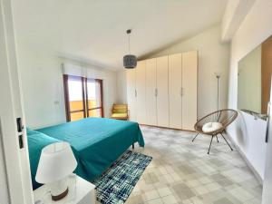 a bedroom with a blue bed and a chair at Casa Cucchiara in Bagnara Calabra