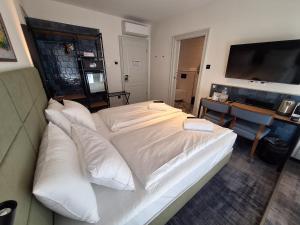 a large white bed in a room with a desk at The 8 Hotel Budapest in Budapest