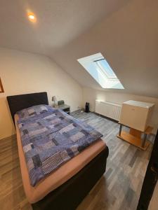 a bedroom with a bed and a skylight at Gästehaus-City in Helmstedt