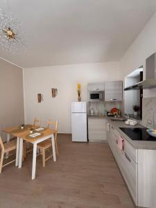 a kitchen with a table and a white refrigerator at B&B Realis Terme in Montagnola