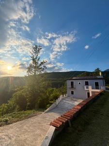 a building on a hill with the sunset in the background at B&B Realis Terme in Montagnola