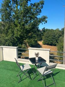 a patio with a table and chairs on the grass at B&B Realis Terme in Montagnola