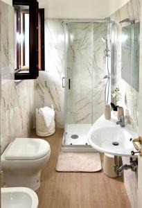 a bathroom with a shower and a toilet and a sink at B&B Realis Terme in Montagnola
