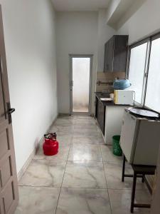 a kitchen with a red pot on the floor at Khushal Residence in Peshawar