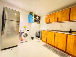 a kitchen with a refrigerator and a washing machine at Majestic Inn in Abu Dhabi +28 photos