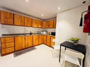 a kitchen with wooden cabinets and a table and chairs at Majestic Inn in Abu Dhabi