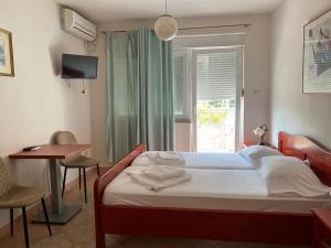 a bedroom with a bed and a table and a window at Vila Ćorović in Kumbor +134 photos