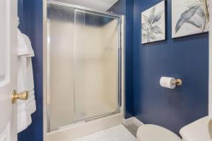 a blue bathroom with a shower and a toilet at Historic Mansion-King Suite-The Royal Crown in Fort Smith
