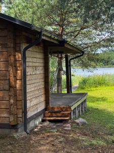 a wooden cabin with a porch and a window at Auksinė giria in Kernavė
