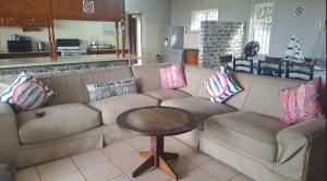 a living room with a couch and a table at Seven Sardines Beach House in Port Edward +33 photos