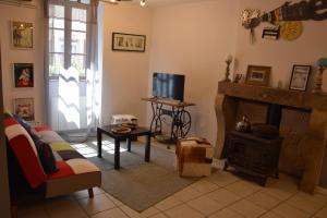 a living room with a couch and a fireplace at La Maison bleue in Rossillon