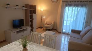 a living room with a couch and a tv on a table at Apartamento primera línea playa d samil in Vigo