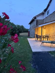 a patio with a table and benches next to a building at La Prairie 65 in Lafitole