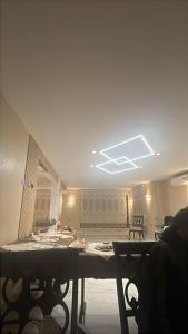 a living room with a table and a ceiling at Antalya Hotel Am in Amman