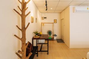 a room with a table and a tree on the wall at Always Boutique Stay 2 in Kampong Huaibū