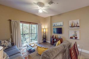 a living room with a couch and a ceiling fan at Exclusive 3BR villa: pools near Disney magic in Kissimmee