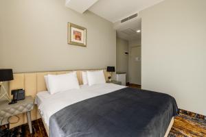a bedroom with a large bed and a desk at Brosse Garden in Tbilisi City