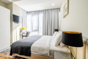 a bedroom with a bed and a large window at Brosse Garden in Tbilisi City +44 photos