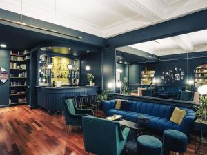 a lobby with a blue couch and a bar at Hôtel Mercure Bayonne Centre Le Grand Hotel in Bayonne
