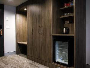 a kitchen with wooden cabinets and a fireplace at Mercure Tamworth in Tamworth