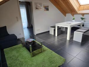 a living room with a white table and a green rug at Haus Motorsport in Bad Saulgau