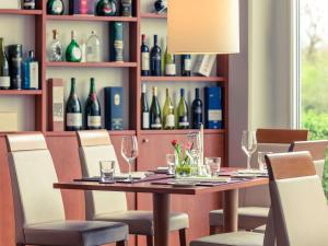 ein Esszimmer mit einem Tisch und Flaschen Wein in der Unterkunft Mercure Hotel Schweinfurt Maininsel in Schweinfurt