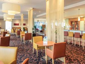 ein Restaurant mit Tischen und Stühlen und einer Bar in der Unterkunft Mercure Hotel Schweinfurt Maininsel in Schweinfurt + 84 Fotos