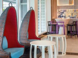 a restaurant with two chairs with tables and a counter at Ibis Styles Phuket City in Phuket