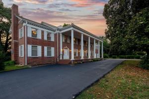 a large brick house with a driveway in front at Historic Mansion-King Suite-The Blue Jay in Fort Smith