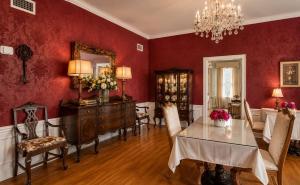 a dining room with red walls and a table and chairs at Historic Mansion-King Suite-The Blue Jay in Fort Smith