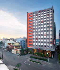 a tall red building on a city street at Ibis Saigon Airport in Ho Chi Minh City