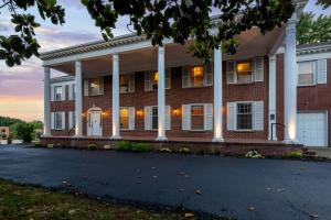 a red brick house with white columns at Historic Mansion-King Suite-The Blue Jay in Fort Smith +11 photos