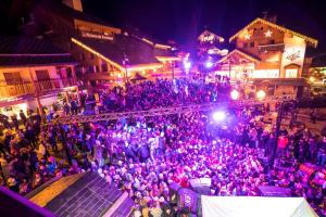 a crowd of people in a street at night at La Taverne in Méribel