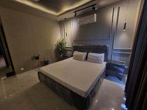 a bedroom with a large bed with white sheets and pillows at 1 Bed Modern Apartment, Pool, Gym, Cinema in Lahore +26 photos