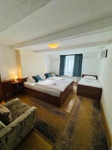 a hotel room with two beds and a couch at Apartments & rooms Velebit in Lovinac +35 photos